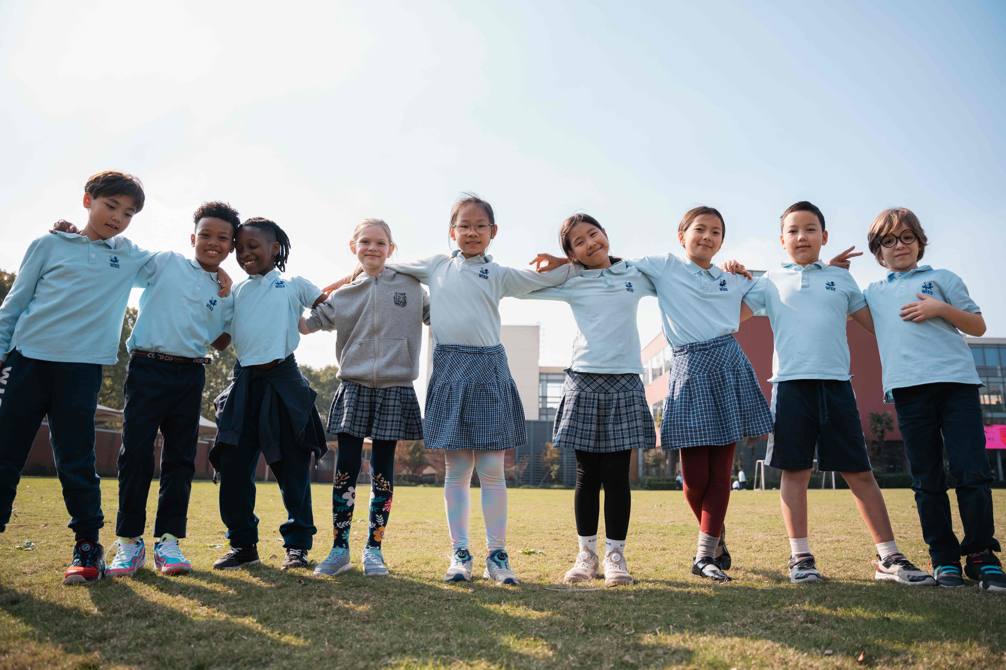 Diverse international school students standing together on campus field
